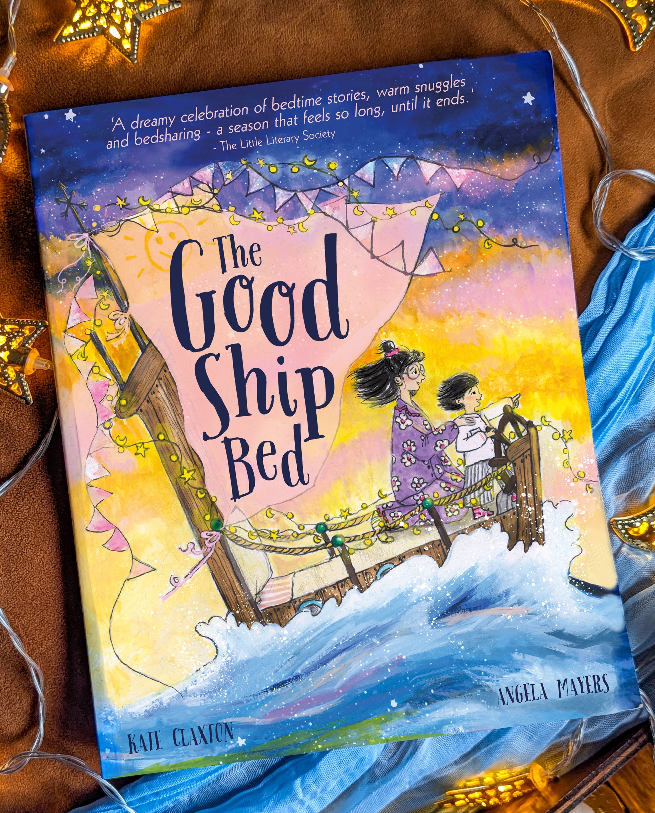 Book titled 'The Good Ship Bed' on a decorative background with stars and lights.